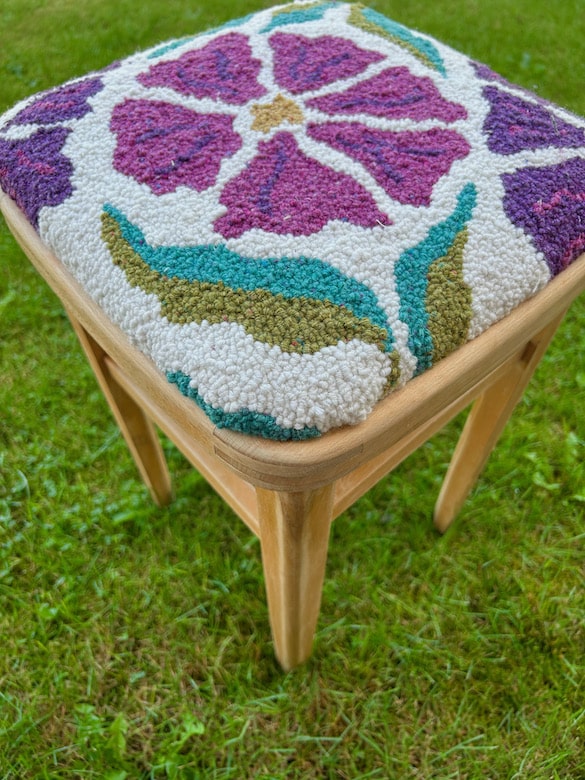 Vintage stool recovered in handmade punch needle seat cover